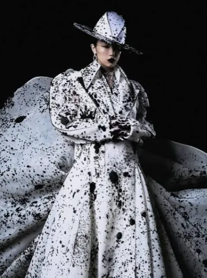 Black and white patterned formal coat with a sculptural hat